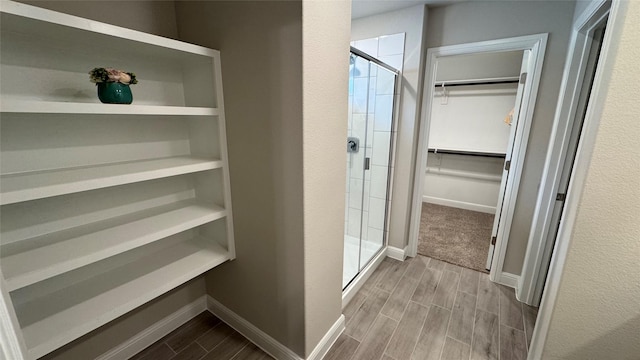 1749 River Bend Rd, Burleson, TX 76028 - bathroom with a walk in closet, wood tiled floors, a shower stall, and baseboards