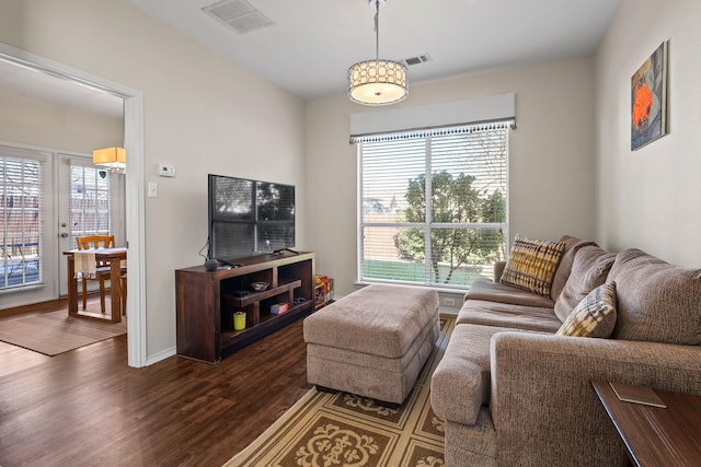 living room featuring dark wood-type flooring, a healthy amount of sunlight, and french doors