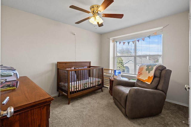 bedroom with ceiling fan, light colored carpet, and a nursery area