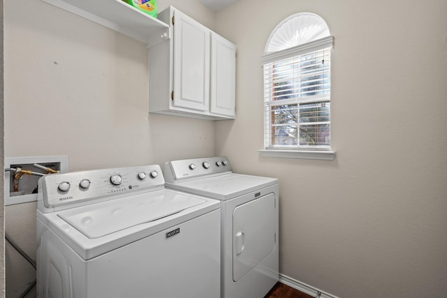 clothes washing area featuring cabinets and washer and dryer