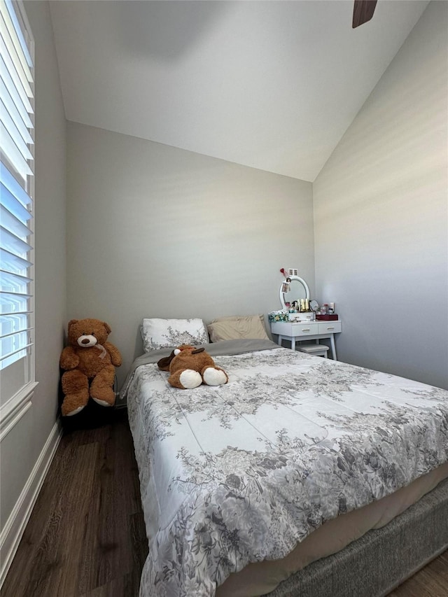 bedroom with ceiling fan, dark hardwood / wood-style flooring, and vaulted ceiling