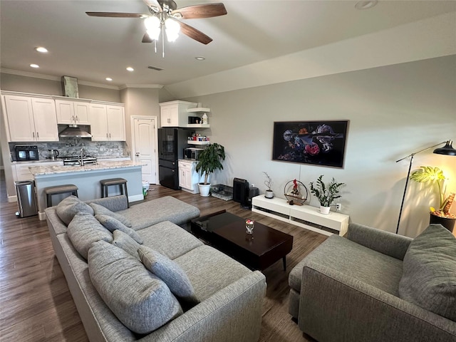 living room featuring crown molding, dark wood-type flooring, and ceiling fan