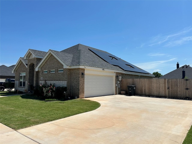 view of side of home with a yard, a garage, and solar panels