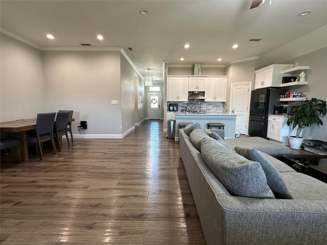 living room with crown molding, ceiling fan, and dark hardwood / wood-style flooring