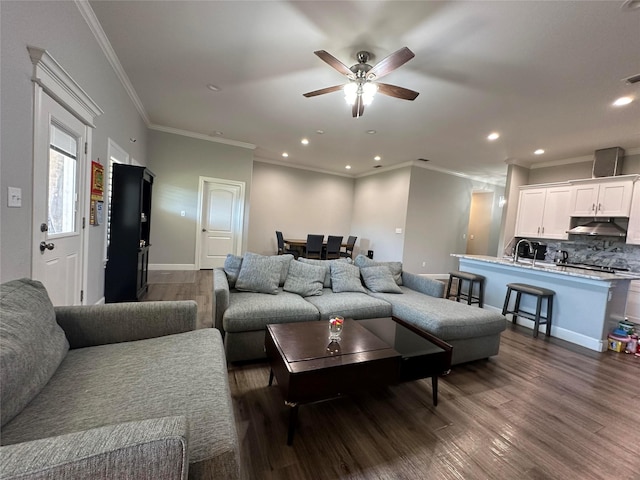 living room featuring ceiling fan, ornamental molding, and dark hardwood / wood-style floors