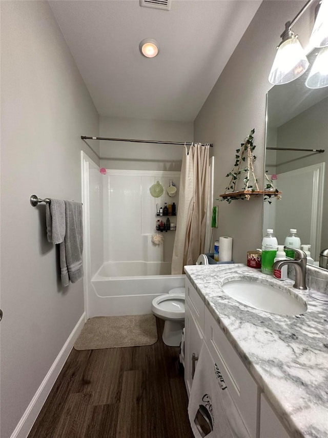 full bathroom with hardwood / wood-style flooring, vanity, toilet, and shower / tub combo