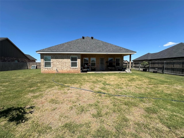 rear view of house featuring a yard and a patio