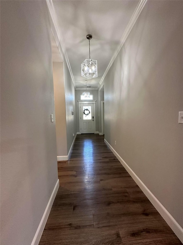 doorway to outside featuring an inviting chandelier, crown molding, and dark hardwood / wood-style floors