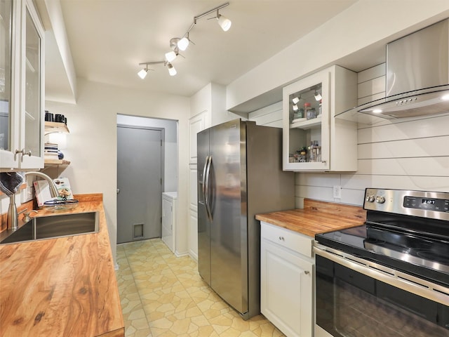 kitchen with sink, stainless steel appliances, white cabinets, wood counters, and wall chimney exhaust hood