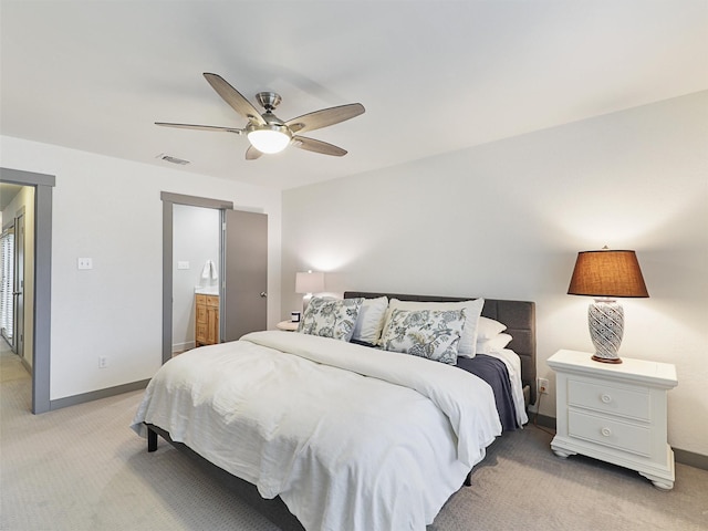 bedroom with ceiling fan, connected bathroom, and light carpet