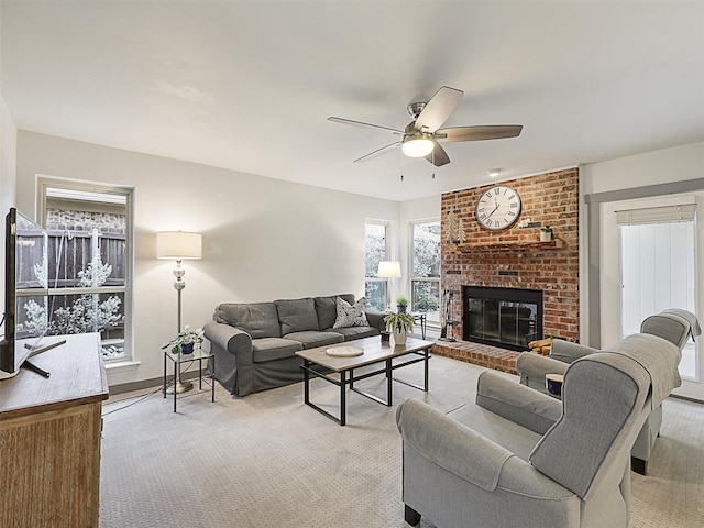 living room featuring light carpet, a brick fireplace, and ceiling fan