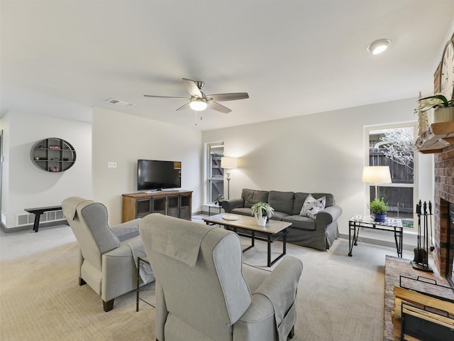 carpeted living room with ceiling fan and a fireplace