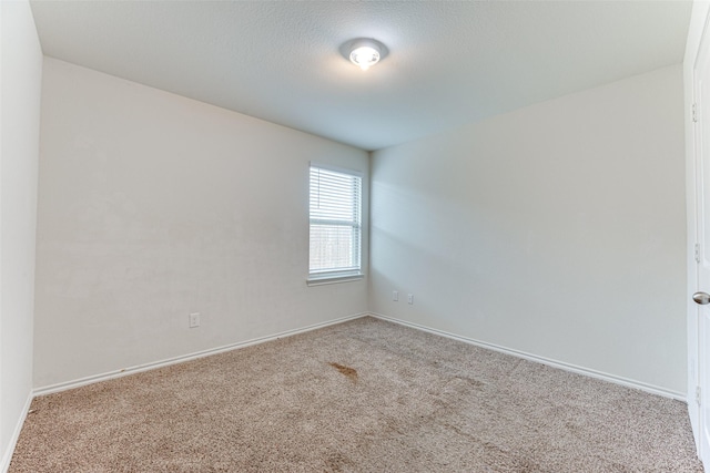 carpeted spare room featuring a textured ceiling