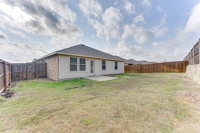 back of house with a patio area and a lawn