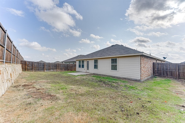 rear view of house featuring a patio and a yard