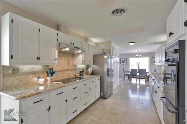 kitchen featuring pendant lighting, light stone counters, tasteful backsplash, black appliances, and white cabinets