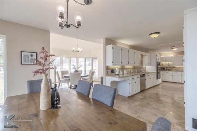 dining space with a chandelier and sink