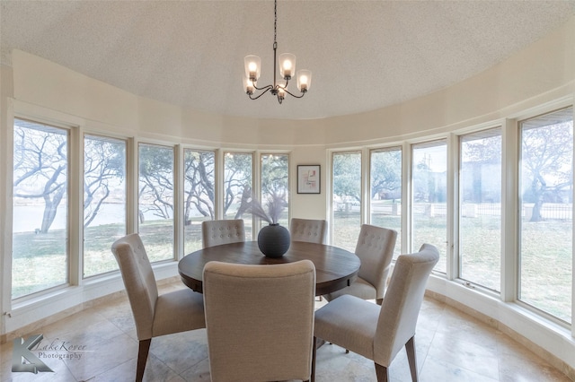 dining space with an inviting chandelier, a textured ceiling, and light tile patterned flooring