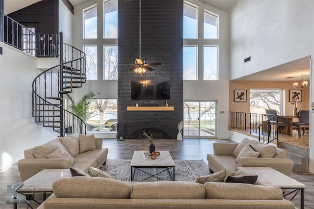 living room with hardwood / wood-style flooring, a large fireplace, and a chandelier