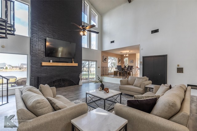 living room featuring wood-type flooring, ceiling fan, and a fireplace