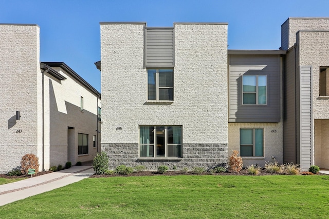 view of front of house featuring a front lawn and brick siding