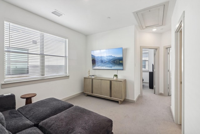 living room featuring attic access, light colored carpet, visible vents, and baseboards