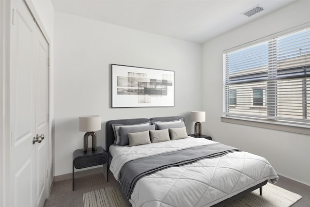 bedroom with carpet, visible vents, baseboards, and a closet