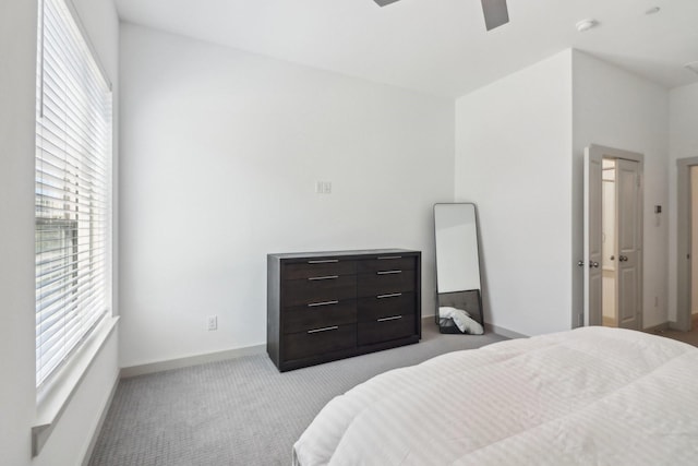 carpeted bedroom with ceiling fan and baseboards