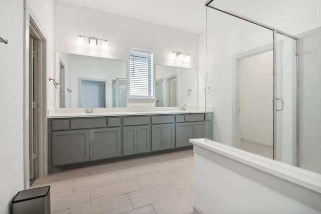 full bath with double vanity, a stall shower, and a sink