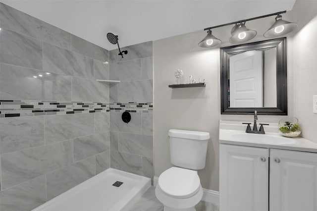 bathroom with vanity, toilet, and a tile shower