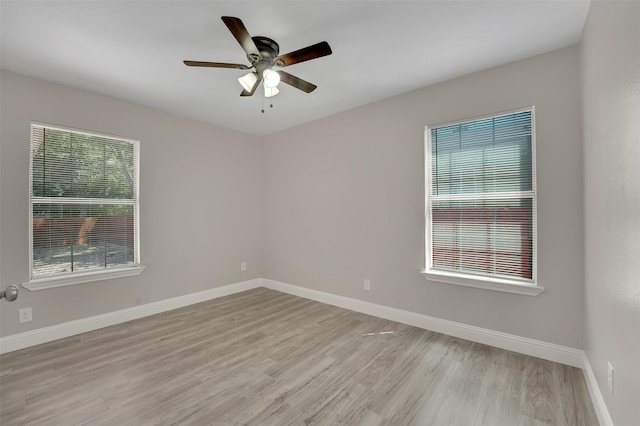 empty room with ceiling fan and light hardwood / wood-style floors