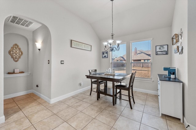 dining space featuring lofted ceiling, light tile patterned floors, and a notable chandelier