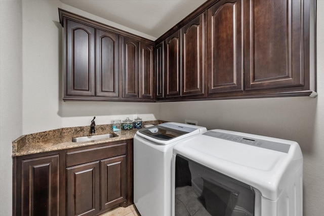 washroom featuring a sink, light tile patterned floors, cabinet space, and washer and clothes dryer