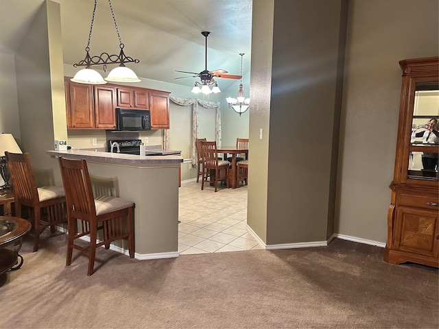 kitchen featuring lofted ceiling, pendant lighting, a kitchen bar, light colored carpet, and kitchen peninsula