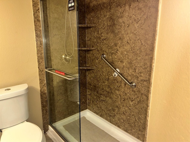 bathroom featuring toilet and tiled shower