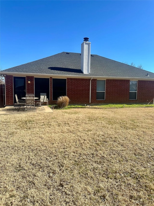 rear view of property featuring a patio and a yard