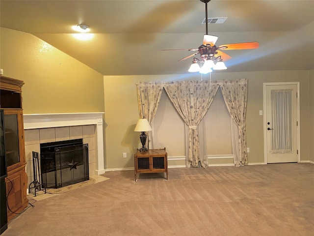 carpeted living room featuring a tiled fireplace and ceiling fan