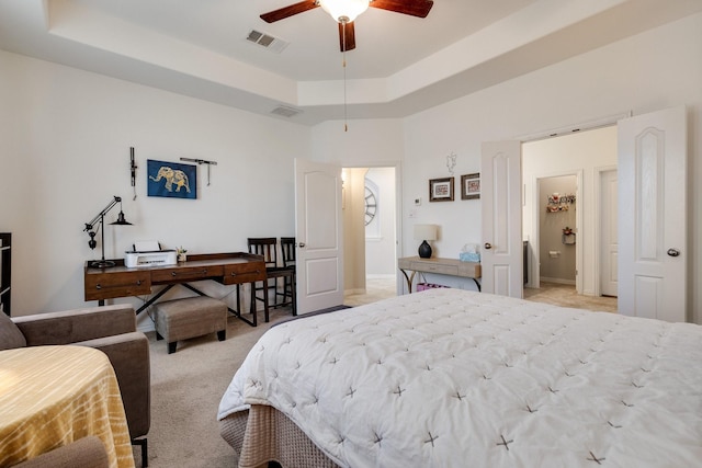 carpeted bedroom featuring a raised ceiling