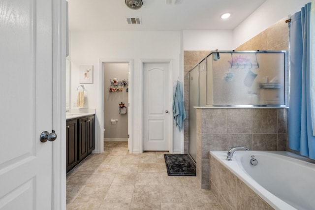 bathroom with vanity, tile patterned flooring, and plus walk in shower