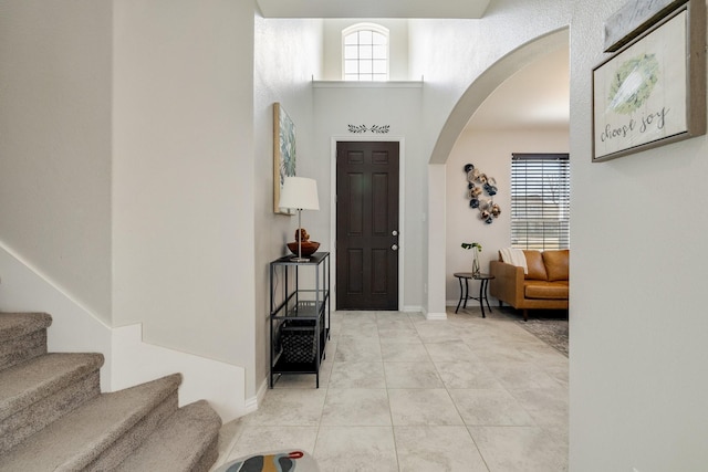 tiled foyer with a towering ceiling