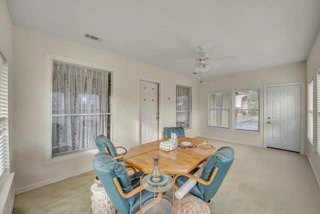 dining space with light colored carpet and ceiling fan