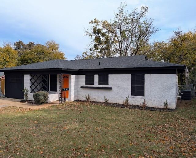 ranch-style house with a front yard and central air condition unit