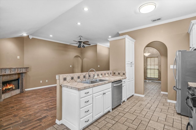 kitchen with sink, crown molding, stainless steel appliances, and white cabinets