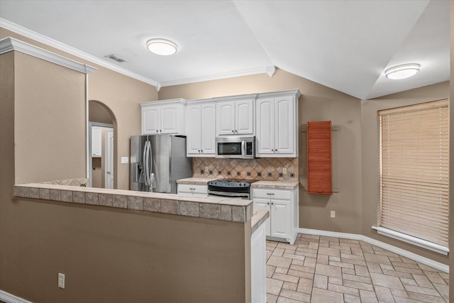 kitchen with appliances with stainless steel finishes, tasteful backsplash, white cabinets, kitchen peninsula, and crown molding