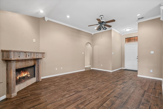 unfurnished living room featuring dark hardwood / wood-style flooring, crown molding, a fireplace, and ceiling fan