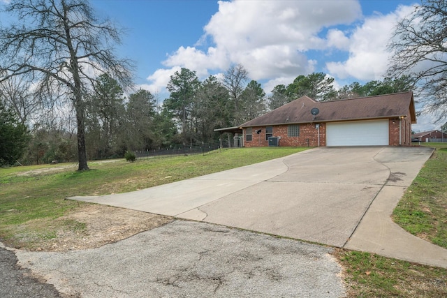 view of front facade with cooling unit, a garage, and a front yard