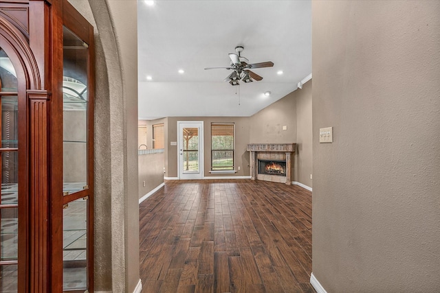 unfurnished living room with dark wood-type flooring, ceiling fan, and lofted ceiling