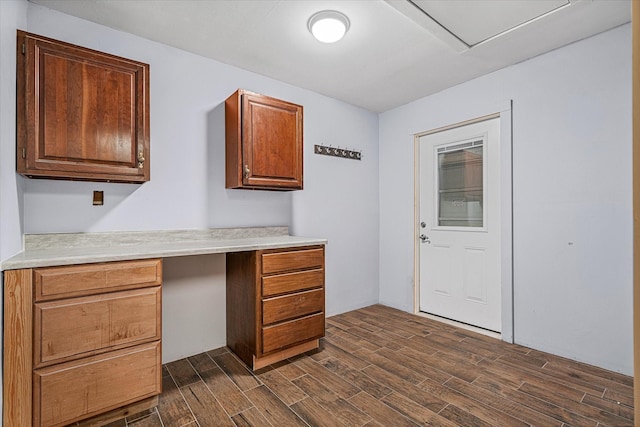 kitchen featuring built in desk and dark wood-type flooring