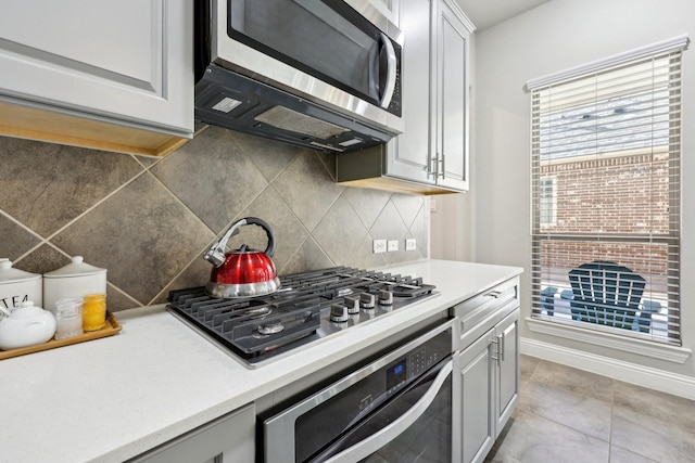 kitchen with tasteful backsplash, light tile patterned floors, and appliances with stainless steel finishes