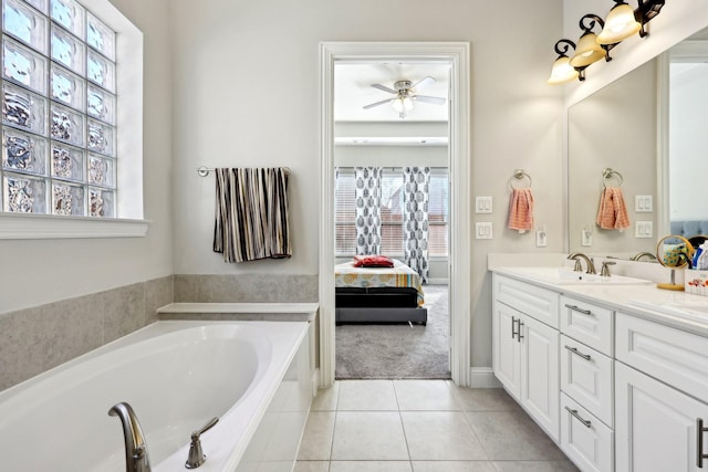 bathroom with tile patterned flooring, vanity, a relaxing tiled tub, and ceiling fan